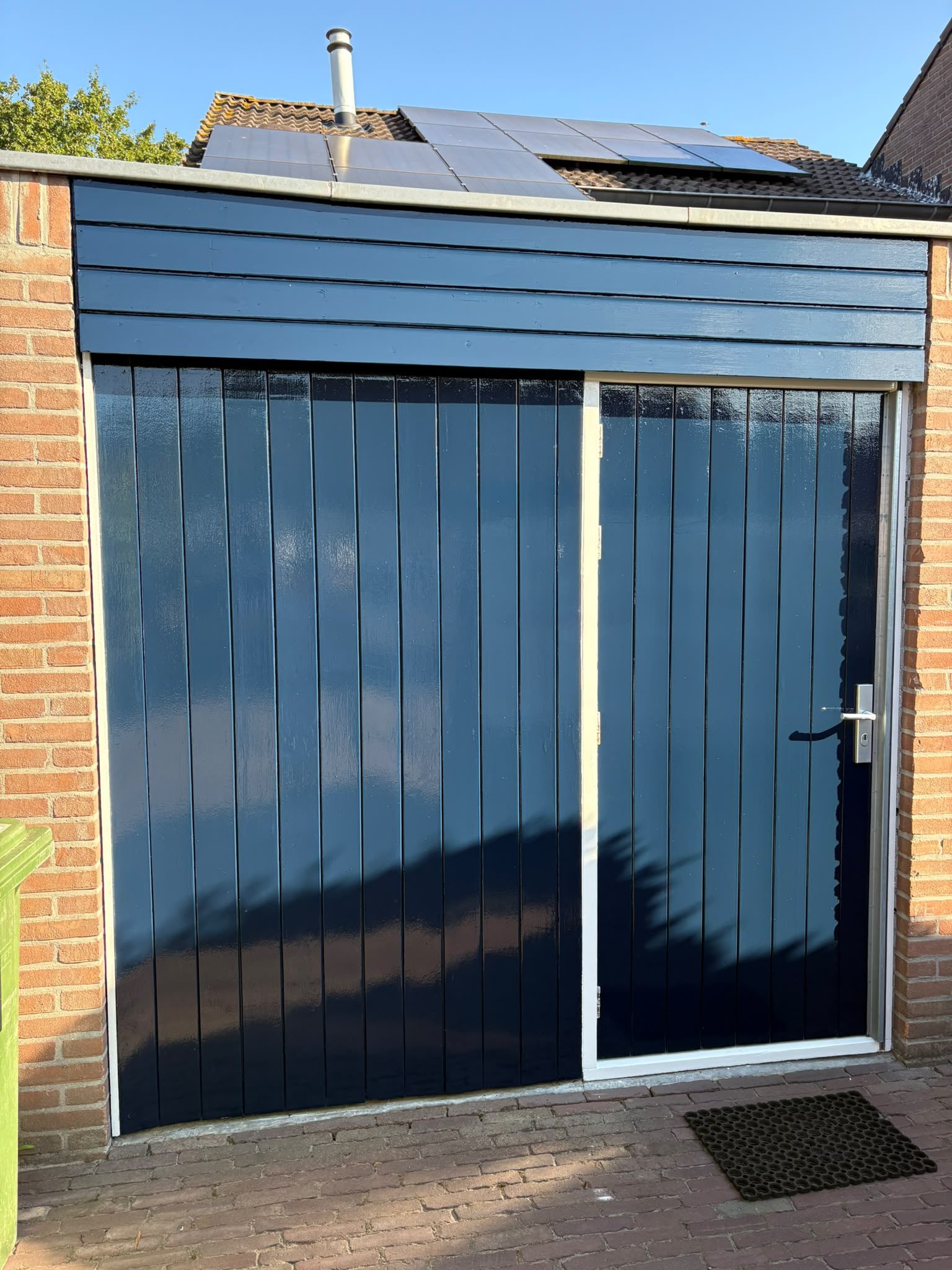Berging met garagedeur blauw hoogglans geschilderd